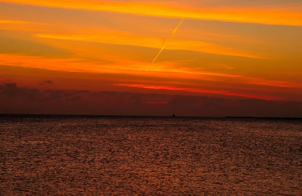 Puesta de sol misteriosa sobre el mar Rojo. Sol, cielo colorido y nubes sobre el mar oscuro —  Fotos de Stock