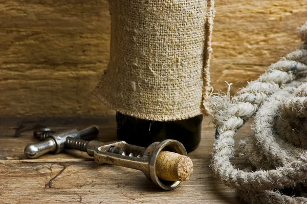Old corkscrew with a cork and a bottle — Stock Photo, Image