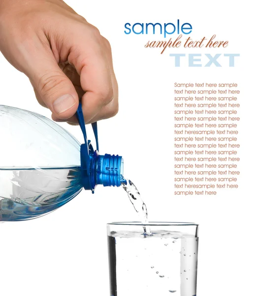 Despeje água de uma garrafa em um copo — Fotografia de Stock