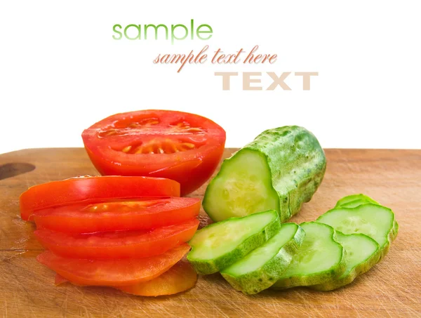 Cucumber and tomato slices on a cutting board — Stock Photo, Image