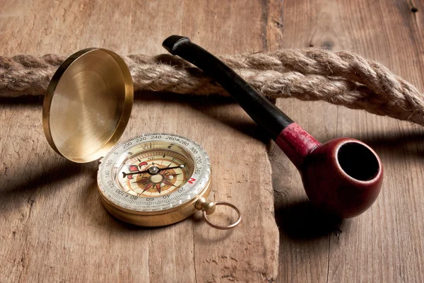 Compass and a pipe with a rope — Stock Photo, Image
