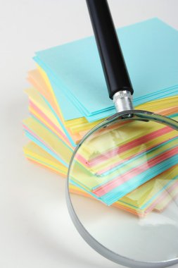 Magnifier enlarges the stack of sheets clipart