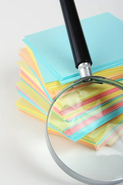 Magnifier enlarges the stack of sheets — Stock Photo, Image