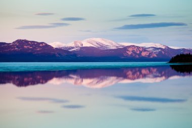 Spring sunset mirrored on Lake Laberge, Yukon, Canada clipart