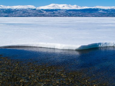 montañas nevadas en el congelado Lago laberge, yukon, Canadá