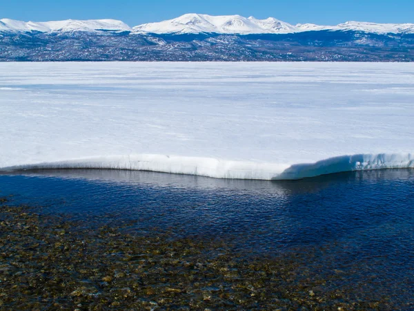 Schneebedeckte Berge am zugefrorenen See Laberge, Yukon, Kanada — Stockfoto
