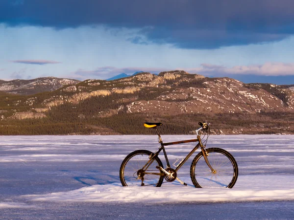 Bicicleta no lago Laberge congelado, Yukon, Canadá — Fotografia de Stock