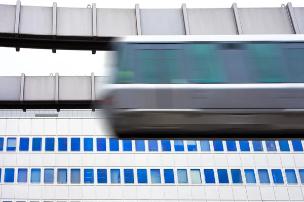 Sky-Train быстро проезжает перед офисным зданием — стоковое фото