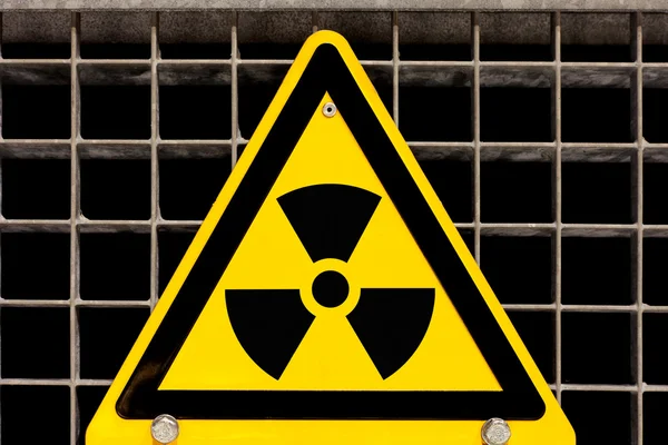 Panneau radioactif boulonné sur grille en acier — Photo
