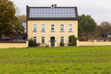 Historic house with solar panels on roof clipart