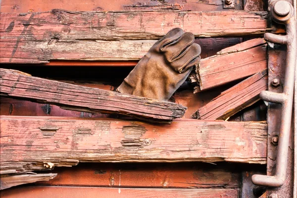 Çürümüş ahşap yan duvarında bulunan eski deri eldiven — Stok fotoğraf