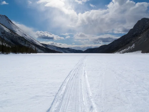 Trilha de inverno bem usada no lago congelado da montanha — Fotografia de Stock