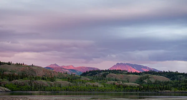 Entfernte Yukon-Berge leuchten im Licht des Sonnenuntergangs — Stockfoto