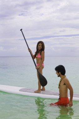 beachboy paddleboard genç kadına öğretir