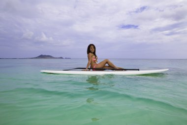 Kadın pembe bikini bir paddle kurulu