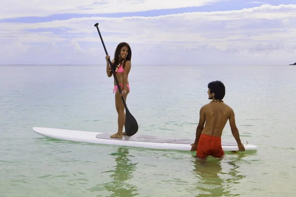 Beachboy uczy młodą kobietę do paddleboard — Zdjęcie stockowe
