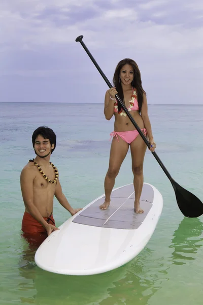 Beachboy teaches young woman to paddleboard — Stock Photo, Image