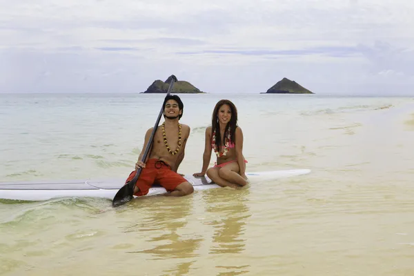 Garçon de plage avec fille en bikini sur planche à pagaie — Photo