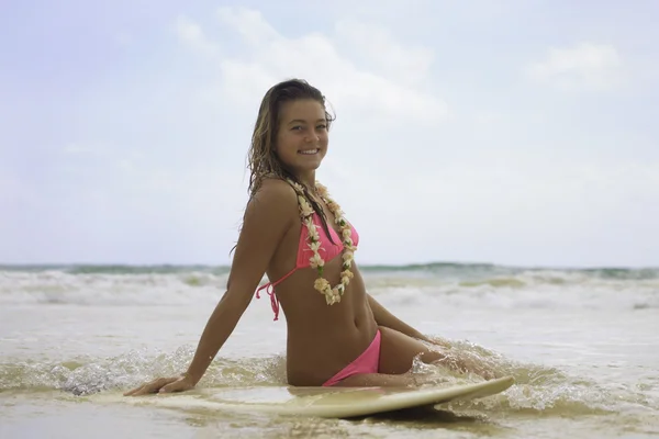 Tienermeisje in roze bikini met haar surfboard — Stockfoto