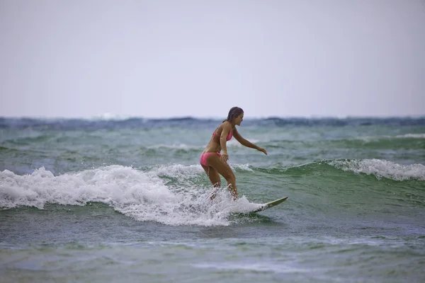 Adolescente en bikini rose avec sa planche de surf — Photo