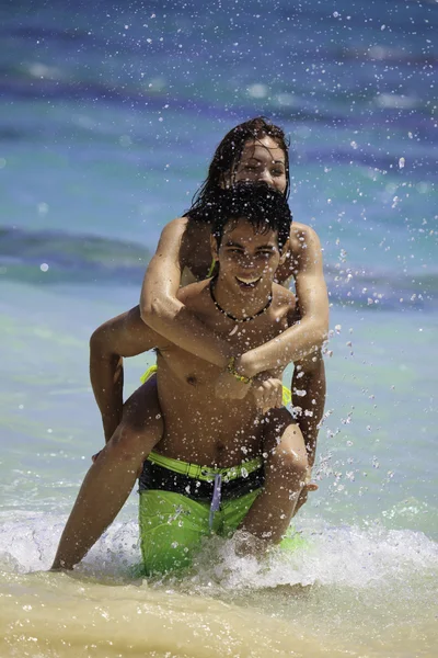 Couple in the ocean riding piggyback — Stock Photo, Image