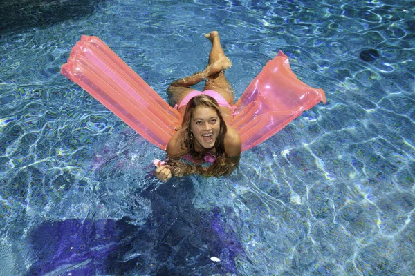 Meisje in roze bikini spelen in een pool — Stockfoto