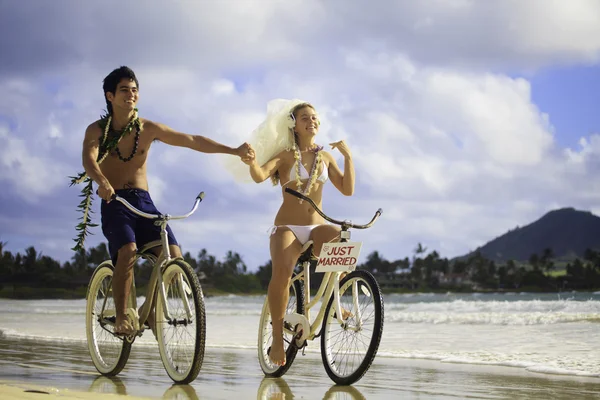 Nygift par på stranden med sina cyklar — Stockfoto
