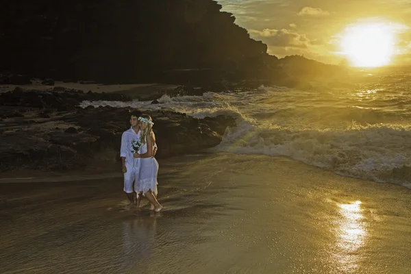 Jonggehuwde paar bij zonsopgang op eeuwigheid strand, hawaii — Stockfoto