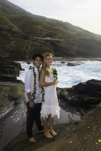 Pareja recién casada en acantilados de lava junto al océano Pacífico —  Fotos de Stock