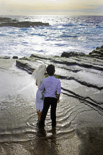 Yeni evli çift lav kayalıklarla tarafından Pasifik Okyanusu üzerinde — Stok fotoğraf