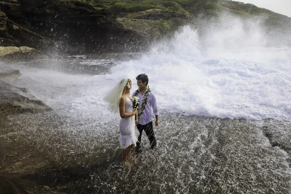 Frischvermähltes Paar auf Lavaklippen am Pazifik — Stockfoto
