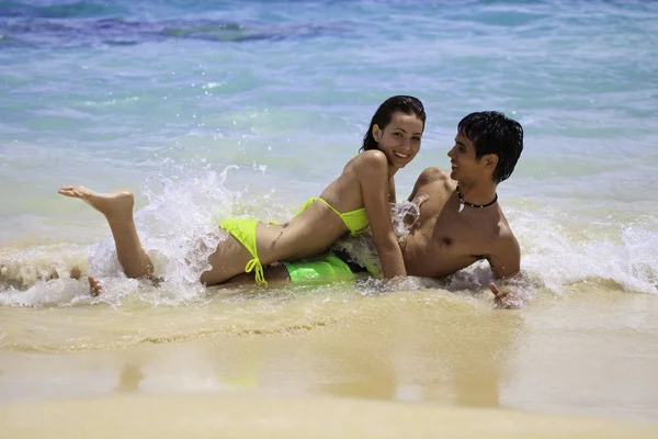 Пара, играющая на краю воды на гавайском пляже — стоковое фото