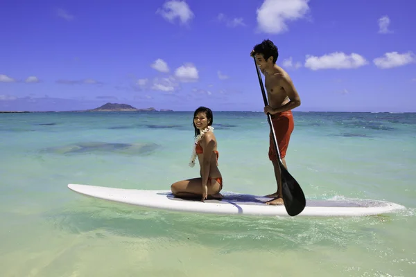 Young couple with their paddle board in hawaii — Stock Photo, Image