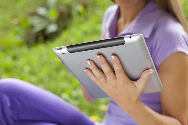 Tablet computador na mão de bela jovem mulher no parque — Fotografia de Stock