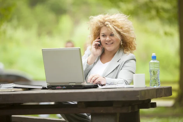 Femme utilisant un ordinateur portable dans le parc — Photo
