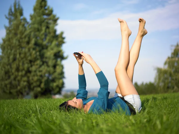 Young woman using mobile phone in park — Stock Photo, Image