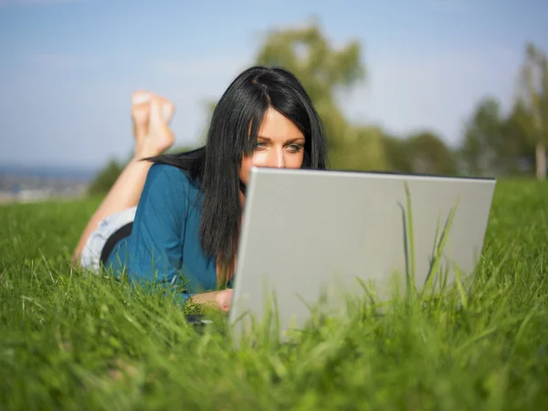 Jovem mulher usando laptop no parque — Fotografia de Stock