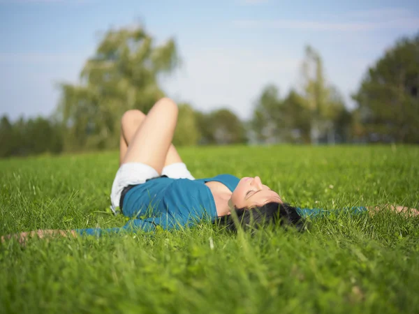 Žena leží na trávě — Stock fotografie