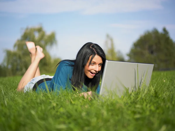Młoda kobieta za pomocą laptopa w parku — Zdjęcie stockowe