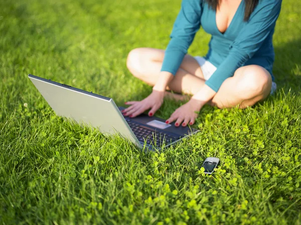 Fiatal nő segítségével a laptop és mozgatható telefon — Stock Fotó