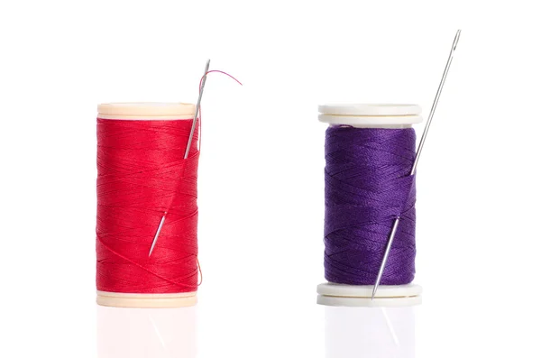 Dos rojo y púrpura hilo bobina y aguja — Foto de Stock