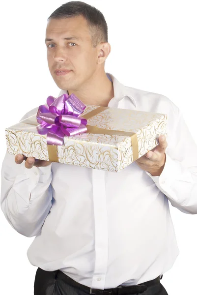 O homem feliz em um fundo branco com um presente comemorativo — Fotografia de Stock
