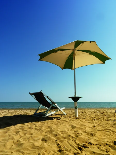 Stoel en paraplu op het strand — Stockfoto