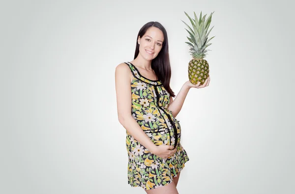 Zwangere vrouw bedrijf ananas — Stockfoto