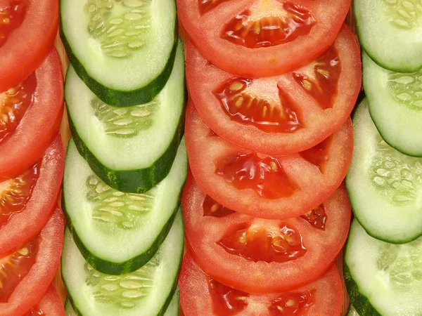 Färska skivade tomater och gurkor som bakgrund. — Stockfoto