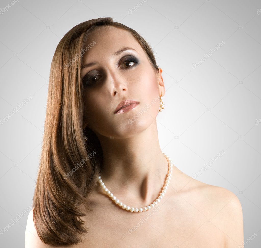 Beautiful face of young woman with pearl necklace.