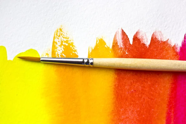 Watercolor brush on the red painted background — Stock Photo, Image