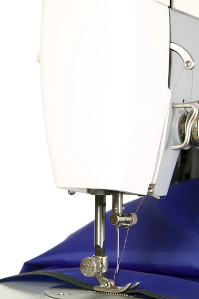 Šicí stroj šije modrou tkaninou — Stock fotografie