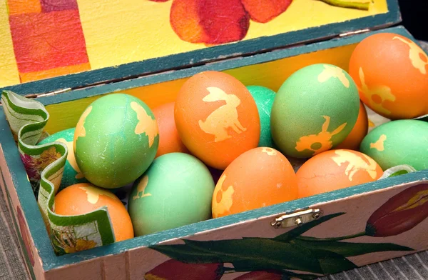 Many colorful ornamented eggs on decorated box — Stock Photo, Image
