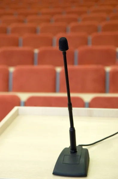 Siyah mikrofon auditorium karşı duruyor — Stok fotoğraf